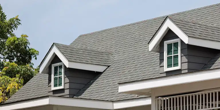 Roofing contractor inspecting a shingle roof