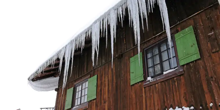 Icicles and an ice dam forming along a roof edge