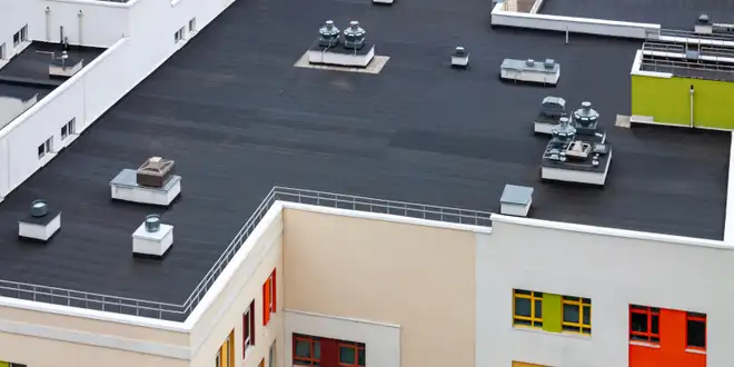 Commercial roofing crew repairing a flat roof on a business building