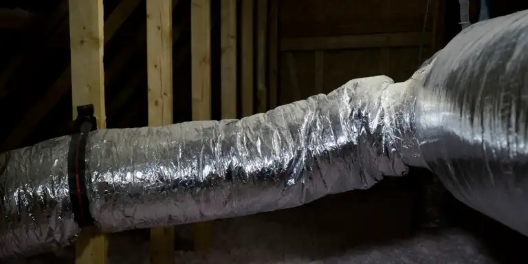 Blown-in insulation being applied inside a Collingwood home
